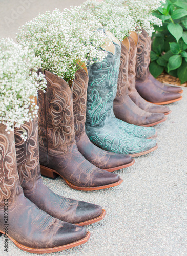 bride and bridesmaids cowboy boots lined up with bouquets, country wedding style, boho chic wedding, babys breath bouquets, wedding photography staging