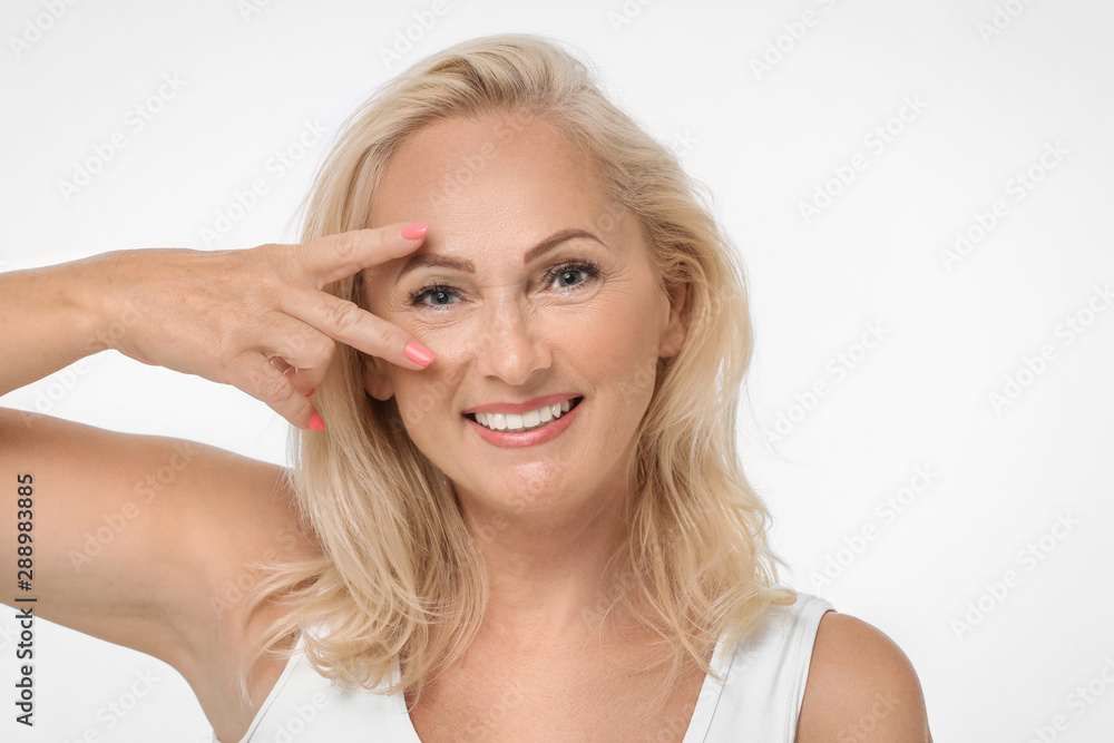 Portrait of beautiful mature woman with perfect skin on white background