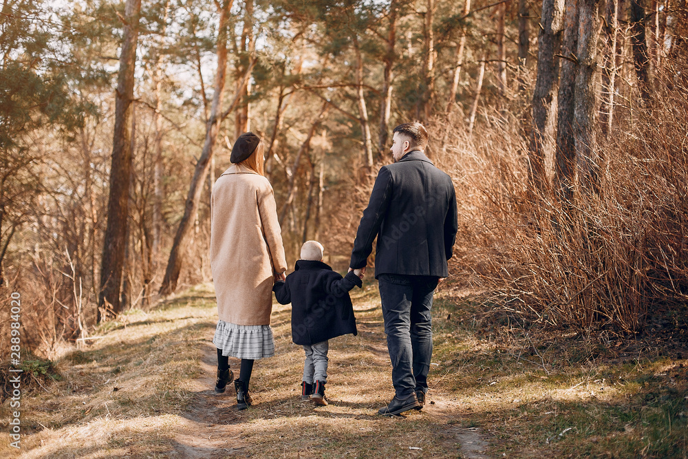 Family with cute little son. Parents with child in a park Family with cute little son. Parents with child in a park