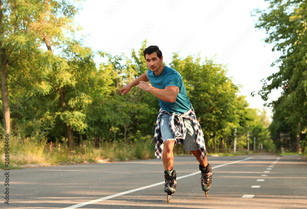 Handsome young man roller skating in park Handsome young man roller skating in park