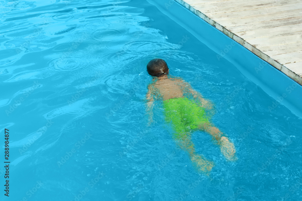 Little child in outdoor swimming pool. Dangerous situation