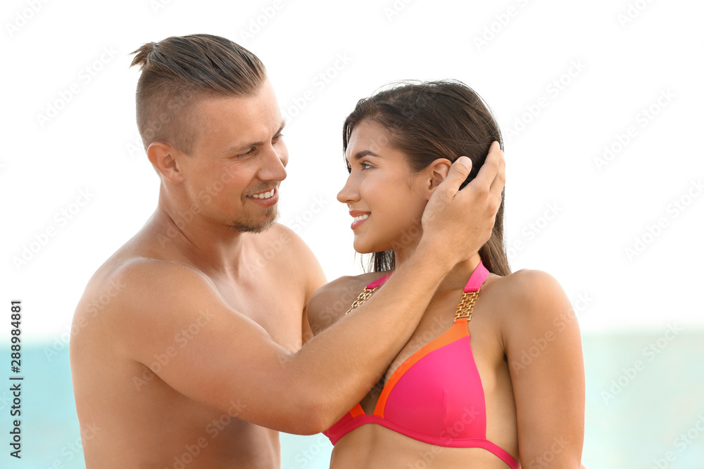 Young woman in bikini spending time with her boyfriend on beach. Lovely couple Young woman in bikini spending time with her boyfriend on beach. Lovely couple