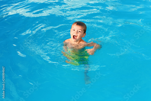 Little child in outdoor swimming pool. Dangerous situation