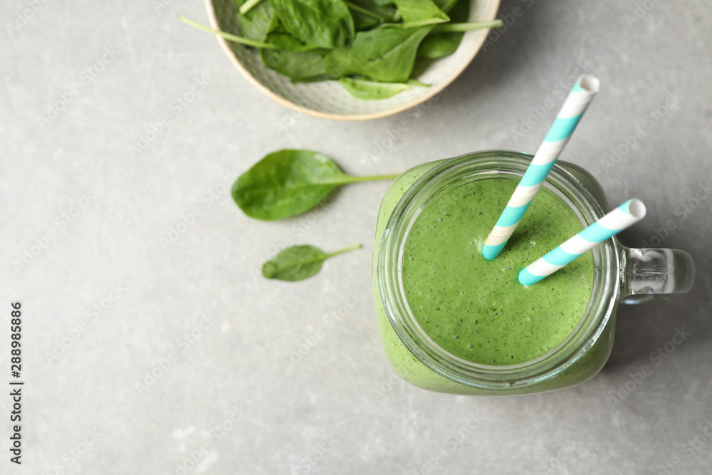 Flat lay composition with fresh green healthy spinach smoothie on grey table. Space for text Flat lay composition with fresh green healthy spinach smoothie on grey table. Space for text