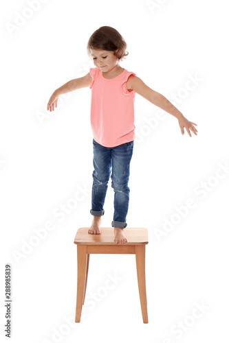 Little girl on stool against white background. Danger at home