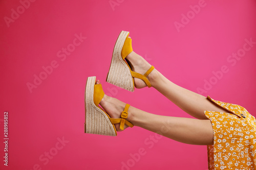 Woman in stylish shoes on pink background