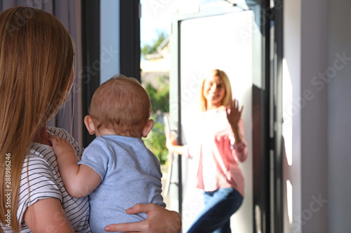 Mother leaving her baby with teen nanny at home. Space for text photo