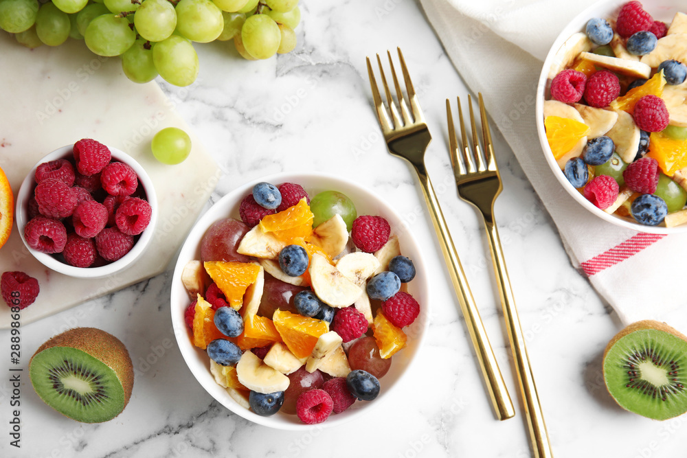 Fresh tasty fruit salad on white marble table, flat lay Fresh tasty fruit salad on white marble table, flat lay