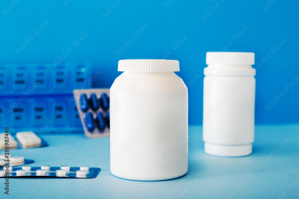 White medical pills and tablets spilling out of a bottle. Mock up bottles with copy space. White medical pills and tablets spilling out of a bottle. Mock up bottles with copy space.