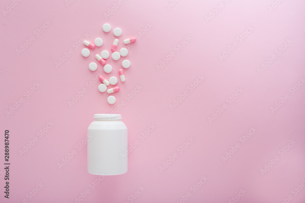 Heap of white and pink pills on pink background. Heap of white and pink pills on pink background.