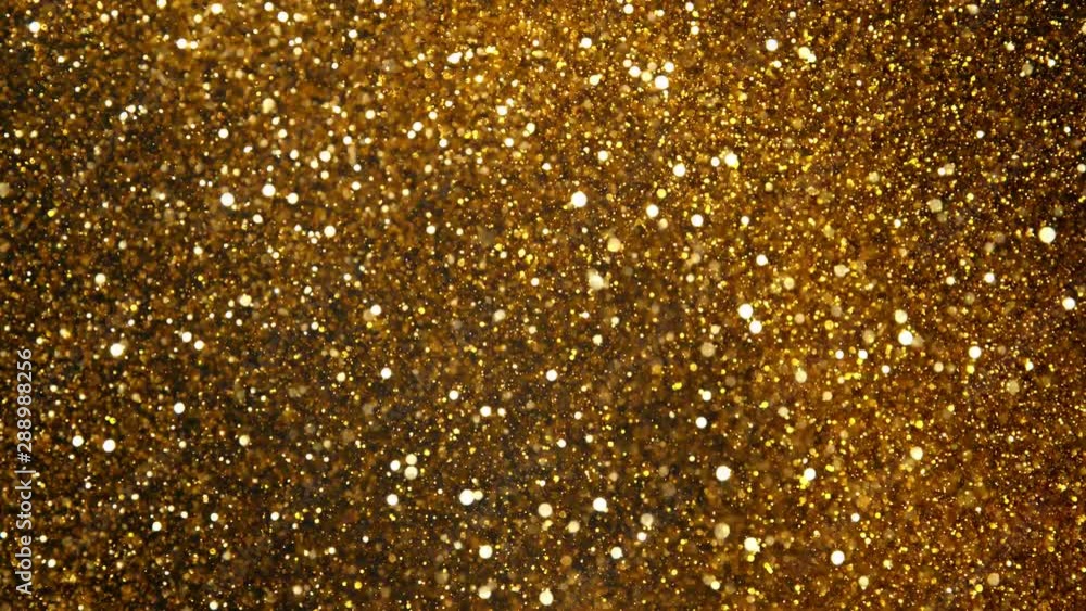 Super slow motion of glittering golden particles on black background. Shallow depth of focus. Filmed on high speed cinema camera, 1000 fps. Super slow motion of glittering golden particles on black background. Shallow depth of focus. Filmed on high speed cinema camera, 1000 fps.