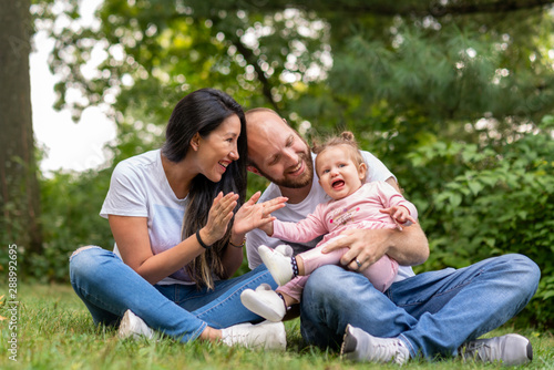 happy family sitting on grass in park