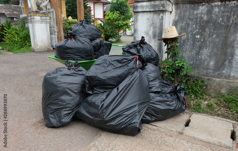 Black plastic bags for packaging waste. Black bin garbage bags in dump land on floor. Black plastic bags for packaging waste. Black bin garbage bags in dump land on floor.