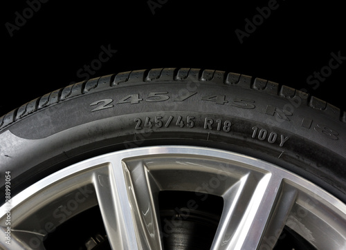 Close up of Number code on sidewall of car tyre with alloy wheel, Tyre Sidewall Markings. photo