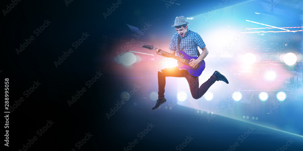 Guitar player in motion on stadium