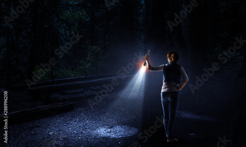 Young woman holding a flashlight