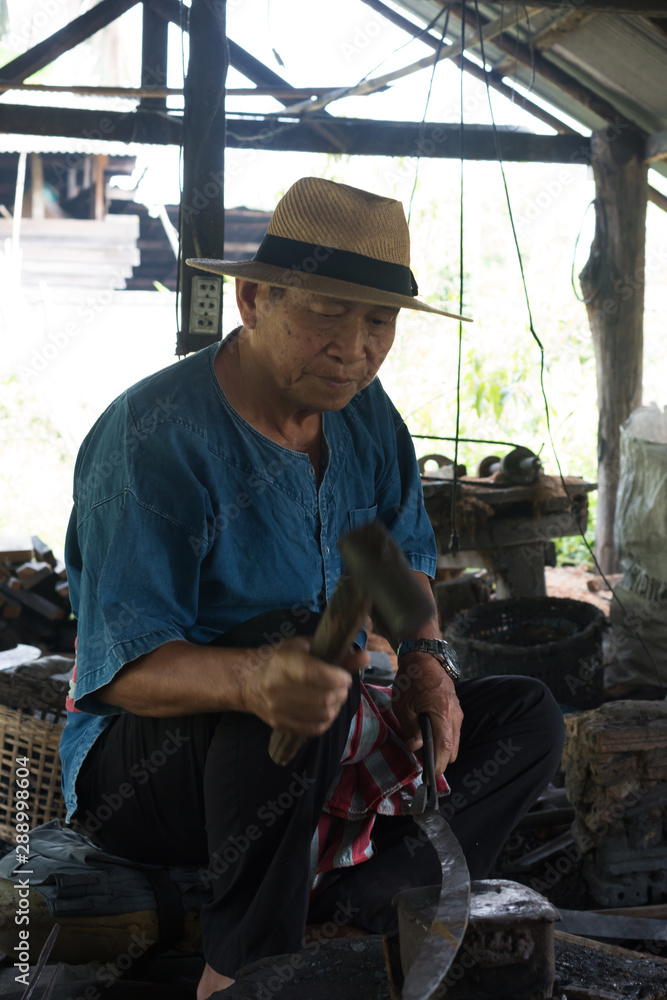 Professional Blacksmith at work is Hit the iron by a hot metal With fire