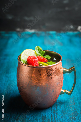 Canvas Print Raspberry and lime cocktail in copper mug (variation of Moscow mule) on the rustic background