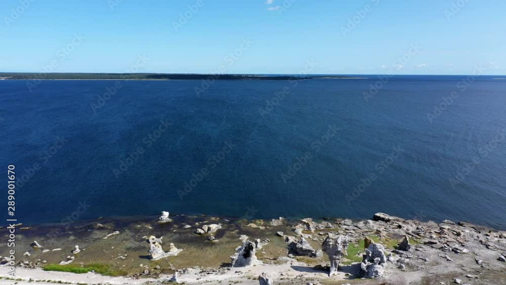 Aerial pull back of famous stone rauk at waterfront in Gotland, Sweden Aerial pull back of famous stone rauk at waterfront in Gotland, Sweden