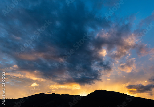 Silhouette of the mighty Pichincha volcano at sunset with sunbeam, Quito City, Ecuador.