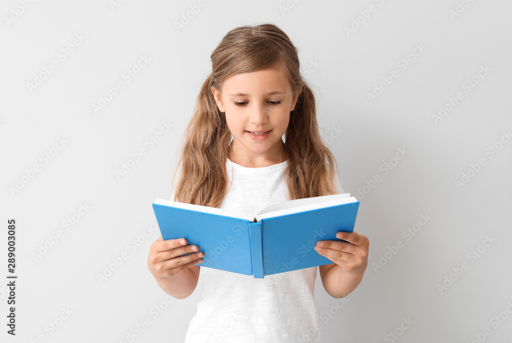 Little girl with book on light background Little girl with book on light background