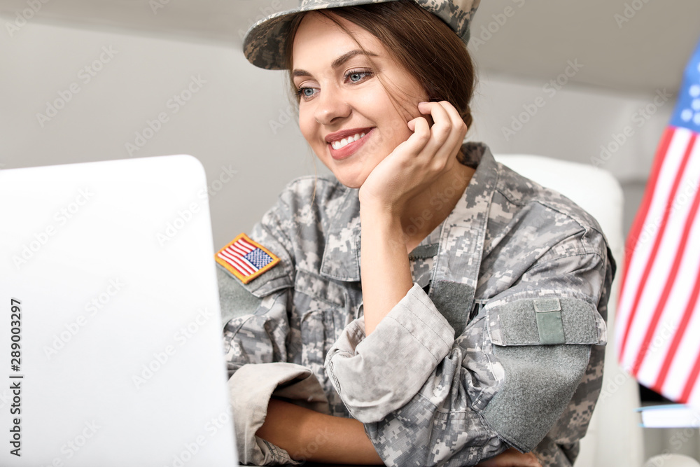 Young female soldier working with laptop in headquarters building Stock ...