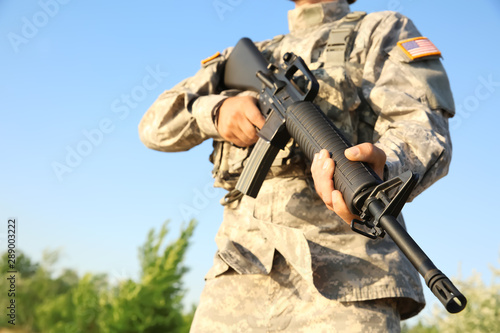 Soldier in camouflage with assault rifle outdoors
