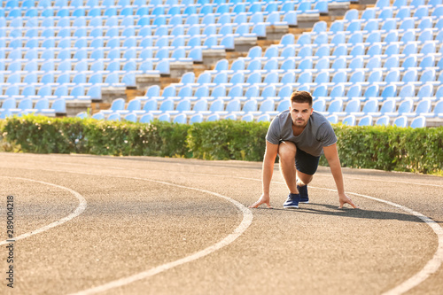 Sporty man in crouch start ...