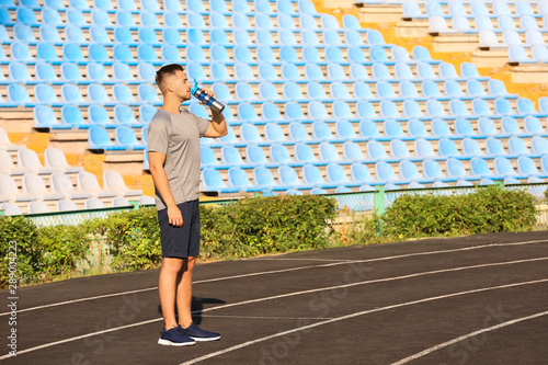 Sporty man drinking water a...