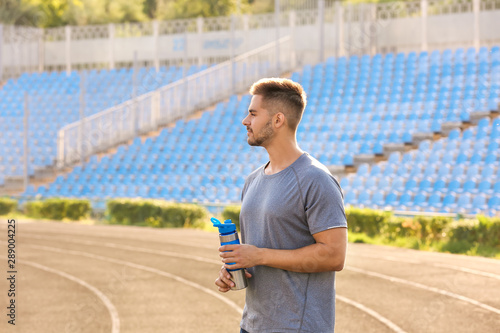Sporty man with bottle of w...