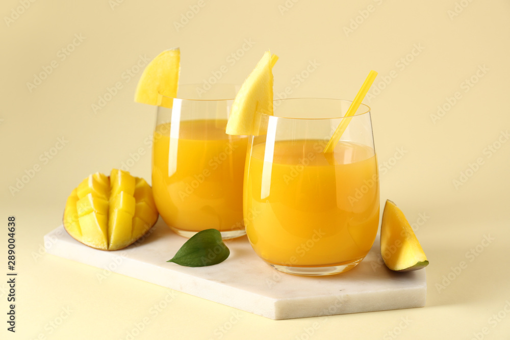 Fototapeta premium Glasses of tasty mango juice on color background