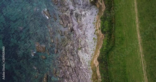 Aerial over head footage of rocky beach on Cornish coast in Looe, Cornwall photo