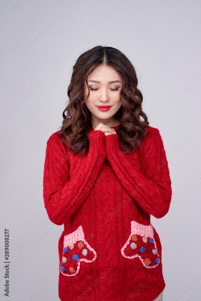Portrait of happy Asian woman in Red Sweater standing and praying. Christmas or New Year wish concept Portrait of happy Asian woman in Red Sweater standing and praying. Christmas or New Year wish concept
