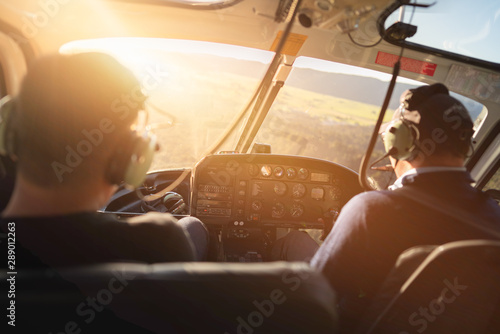 Scene of helicopter cockpit from the rear side which have two pilots at the front seat.