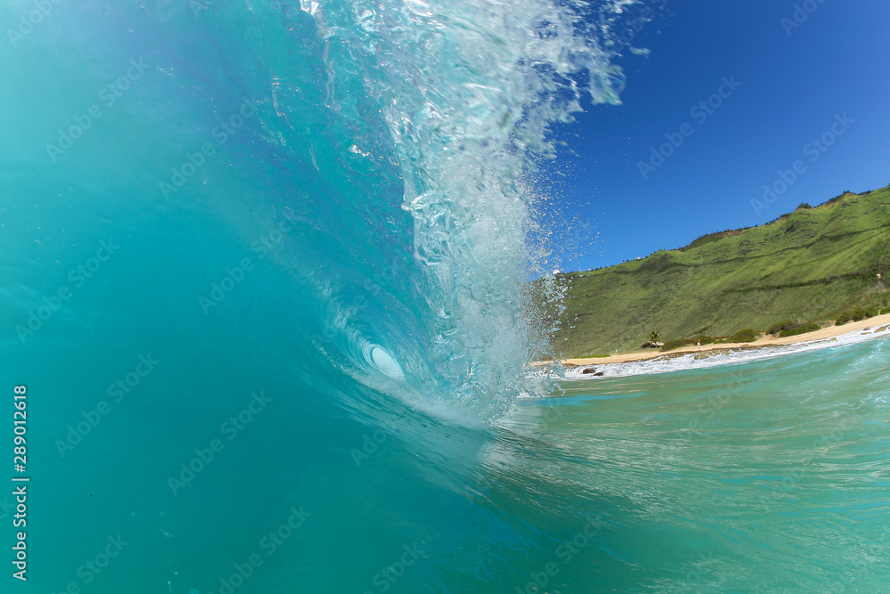 tropical blue wave breaking on a beach