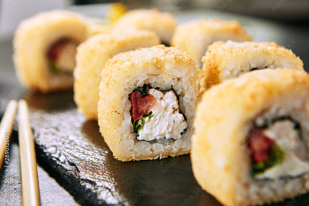 Smoked Chicken Tempura Uramaki Sushi Rolls on Black Background Smoked Chicken Tempura Uramaki Sushi Rolls on Black Background