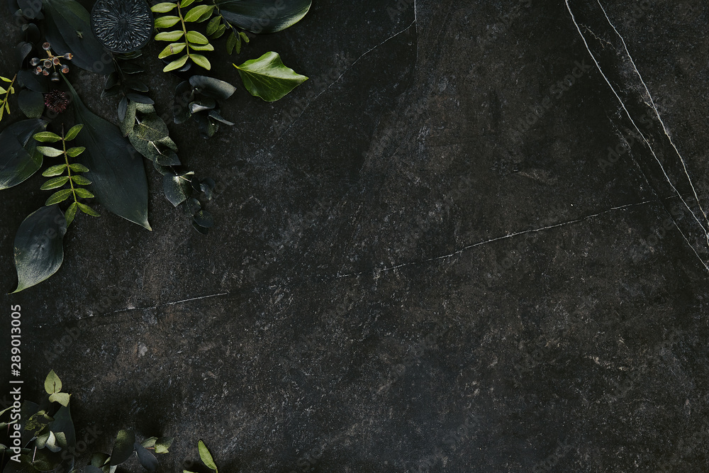 Dark green tropical leaves mockup on natural black stone background - obrazy, fototapety, plakaty 