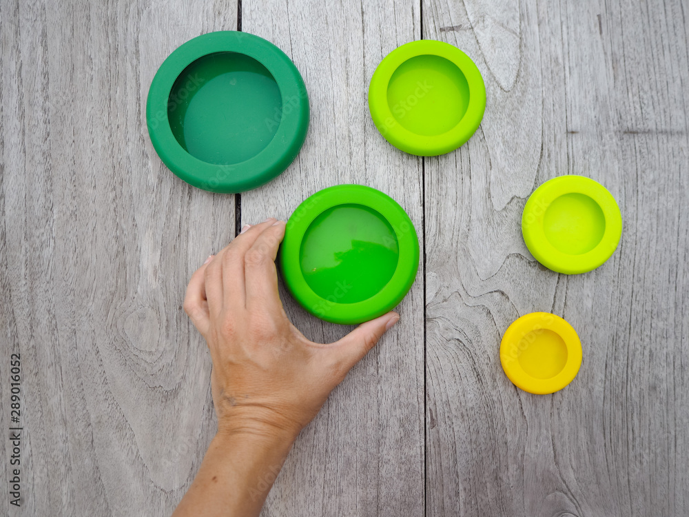Hand holding a reusable silicone food wrap for preserving cut food in a zero waste lifestyle Hand holding a reusable silicone food wrap for preserving cut food in a zero waste lifestyle