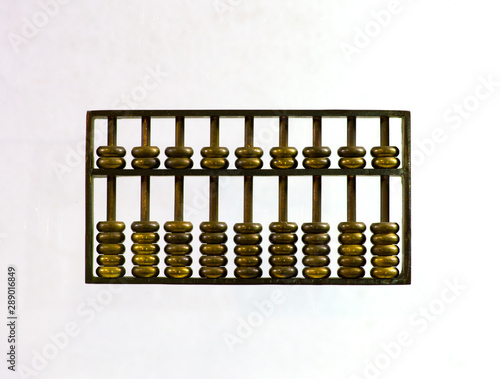 Chinese abacus ancient antique counting machine in bronze metal. Chinese abascus hand mechanical calculating machine. Close up isolated on light background.   photo