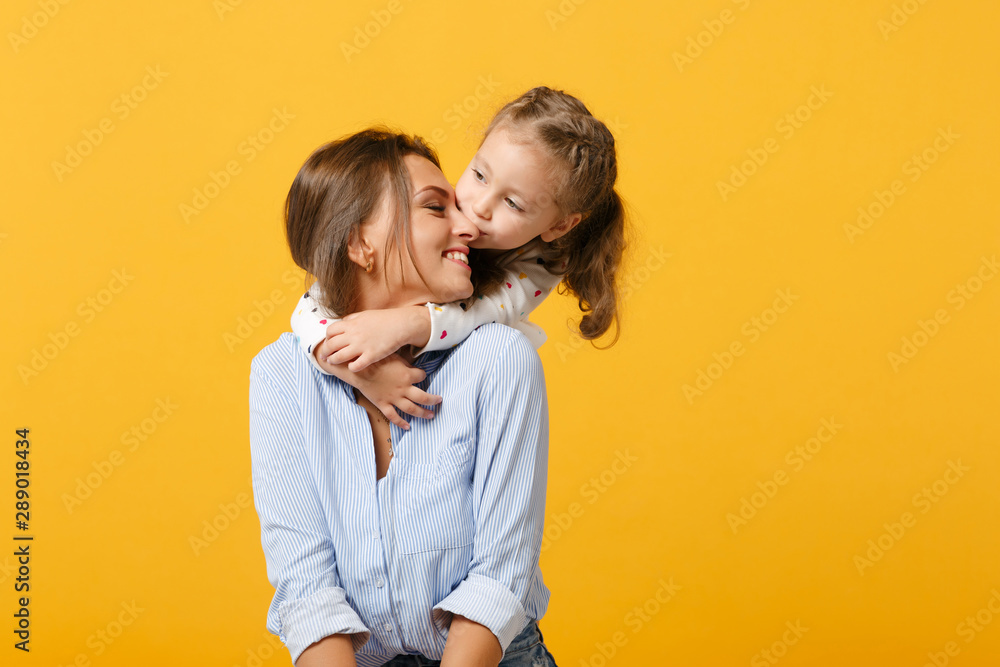 Woman in light clothes have fun with cute child baby girl 4-5 years old. Mommy little kid daughter isolated on yellow background studio portrait. Mother's Day love family parenthood childhood concept. - obrazy, fototapety, plakaty 