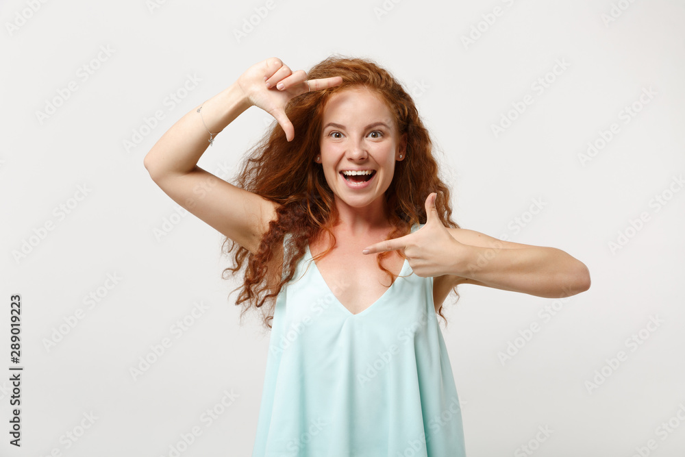 Young cheerful redhead woman girl in casual light clothes posing isolated on white wall background, studio portrait. People lifestyle concept. Mock up copy space. Making hands photo frame gesture. Young cheerful redhead woman girl in casual light clothes posing isolated on white wall background, studio portrait. People lifestyle concept. Mock up copy space. Making hands photo frame gesture.