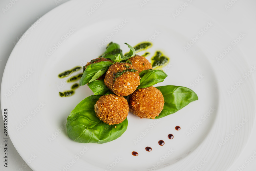 Falafel with pesto and basil on a white plate. Falafel with pesto and basil on a white plate.