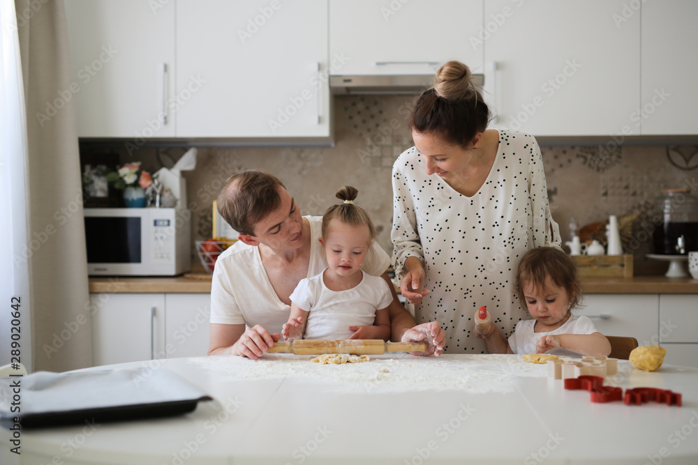 girl with Down syndrome and family in the kitchen girl with Down syndrome and family in the kitchen