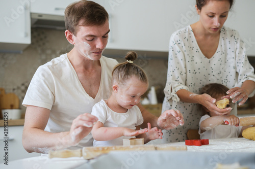 girl with Down syndrome and family in the kitchen