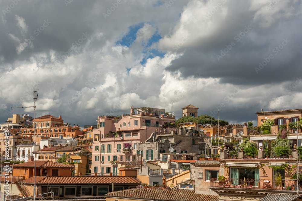 Roman urban landscape of houses with rooftop gardens on a cloudy blue sky background