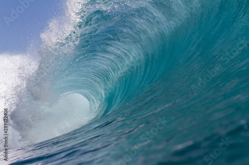 turquoise blue wave breaking on a reef