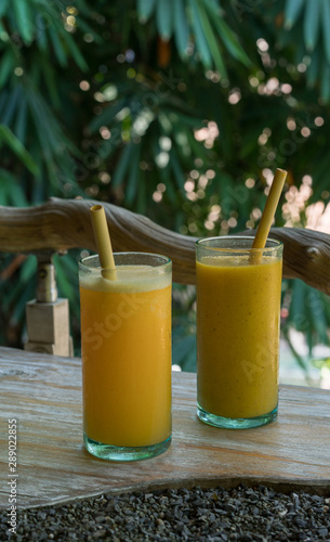 Zero waste concept with reuse bomboo straw, tropical delicious juice, Thai Bali seasonal, cool ice beverage for refreshing in summer on green nature bokeh background photo