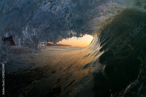 inside view of a breaking wave at sunset over the ocean