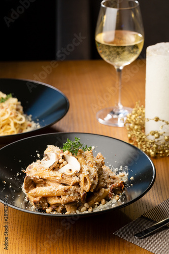 Pasta with mushrooms sauce close-up and wine glass