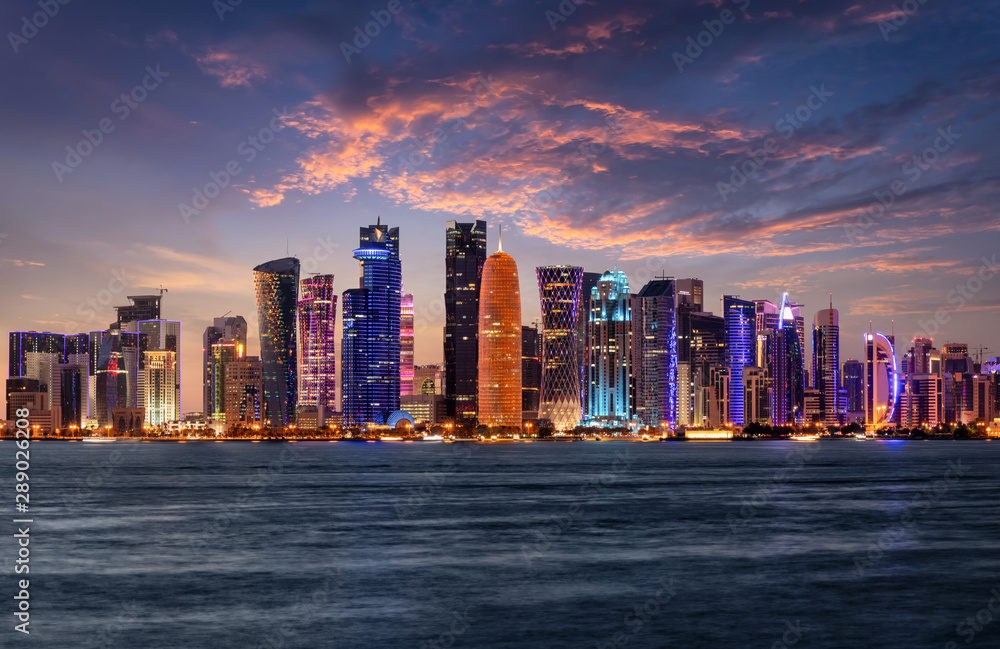 Fototapeta premium Die beleuchtete Skyline von Doha im Staat von Katar am Abend nach Sonnenuntergang
